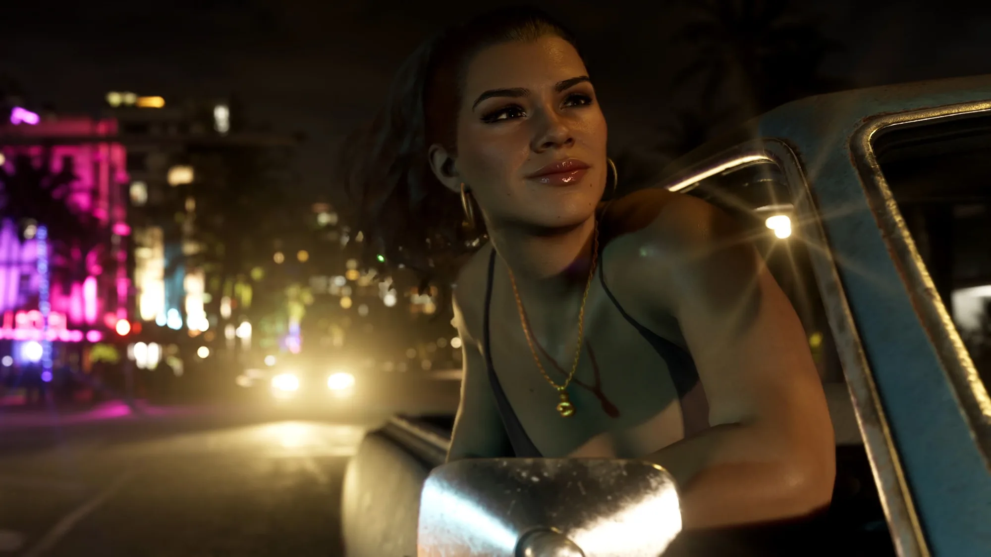 A woman with dark hair and gold jewellery leans out of a car window on a neon-lit city street at night, looking off to the side.