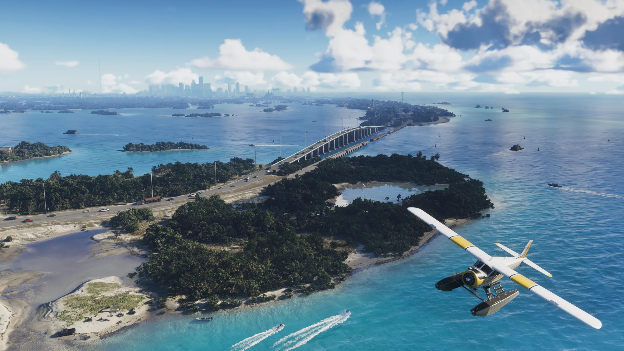 A seaplane with a white and yellow fuselage flies over turquoise water studded with small islands, with a long causeway bridge and a distant city skyline on the horizon.